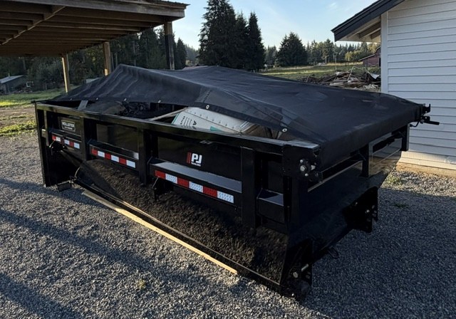 Black roll-off dumpster with tarp cover