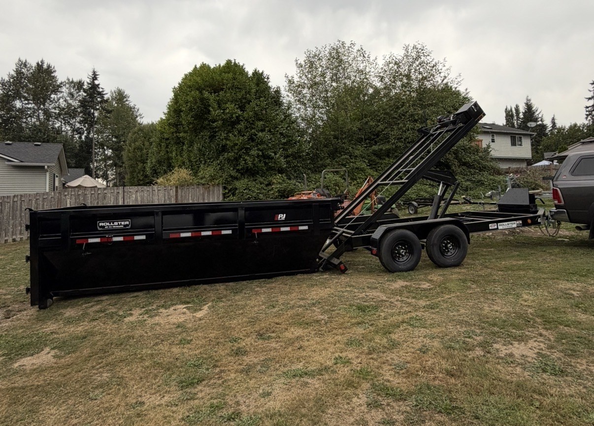 Full view of black roll-off dumpster trailer